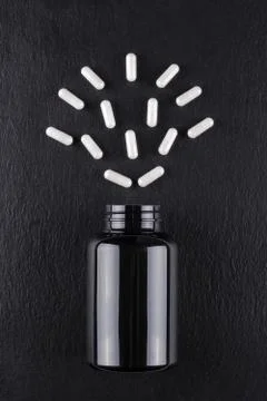 White capsules like a face on black background Stock Photos