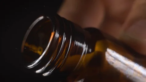 The white capsules fall out of the glass jar.Black background,slow motion,macro Stock Footage 127620115