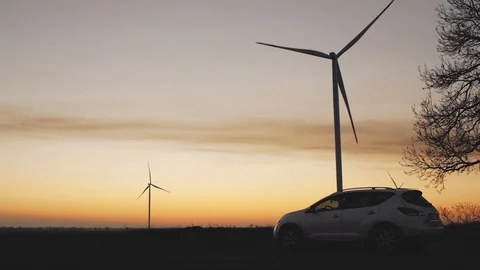White car on the background of wind turbines at sunset Stock Footage 103218252