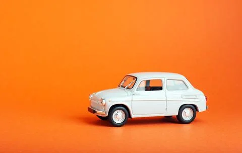 White car on colored background. Model white retro toy car on orange background Stock Photos