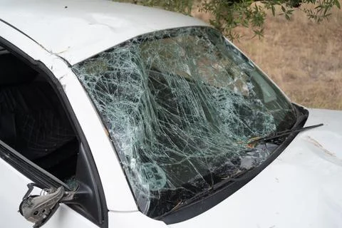 White car with a completely shattered windshield, broken glass, and damaged Stock Photos
