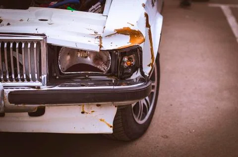 A White Car Crash Details. Dented Front Fender, Bumper and Broken Headlights. Stock Photos