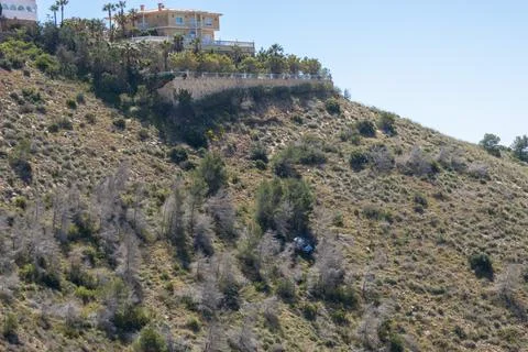 White car crashed and fallen down a steep slope in a hilly area. Stock-Fotos
