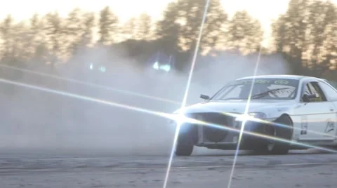 White car drifts around corner on race track at dusk. Stock Footage 59762099