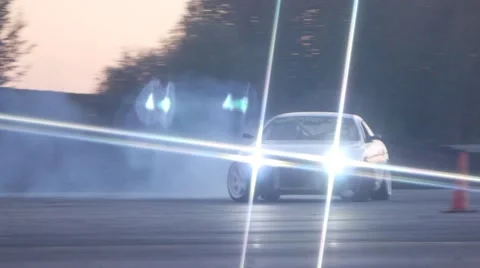 White car drifts around corner in slow motion at dusk during drifting race. Stock Footage 59762358
