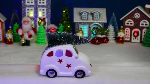 A white car drives against the backdrop of a Christmas village Stock Footage 308568932