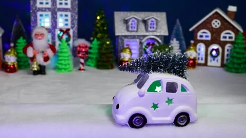 A white car drives against the backdrop of a Christmas village Stock Footage 308568934