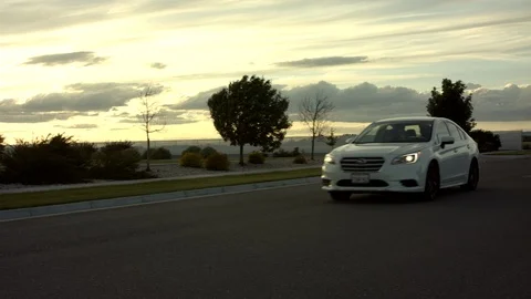 White car driving past camera during golden hour sunset 4k Stock Footage