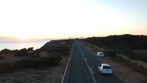 White car driving on the road hat has a cliff Stock Footage 131153852