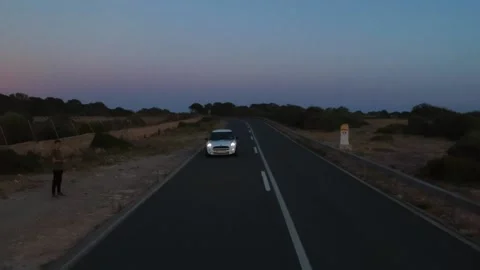 White car driving on the road hat has a cliff Stock Footage 131153882