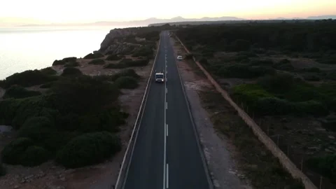 White car driving on the road hat has a cliff Stock Footage 131153885