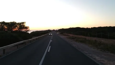 White car driving on the road hat has a cliff Stock Footage 131153989