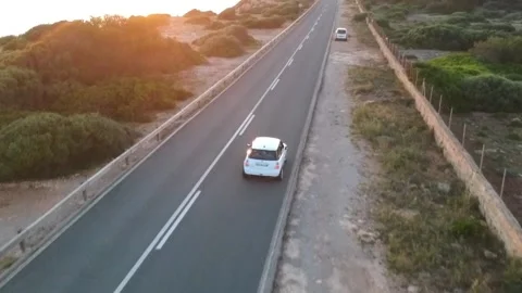 White car driving on the road hat has a cliff Stock Footage 131154009