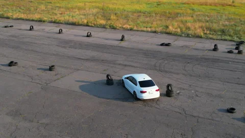 White car drove between old car tires. Poltavska oblast, Ukraine 25.07.2021 Stock Footage 158748849