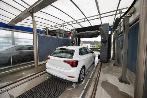 White car getting washed in automatic car wash station Stock Photos