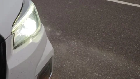 White car LED headlight rays shine through the raindrops Видео 310408386