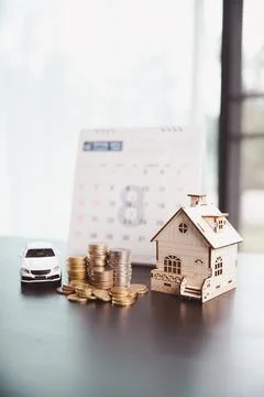 White car model, coin stacks, wooden house, and calendar represent schedule.. Stock Photos