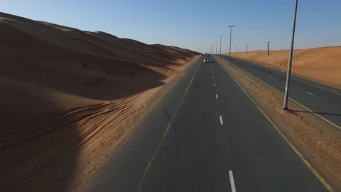 White car moves towards the camera on the desert highway Stock Footage 92682047