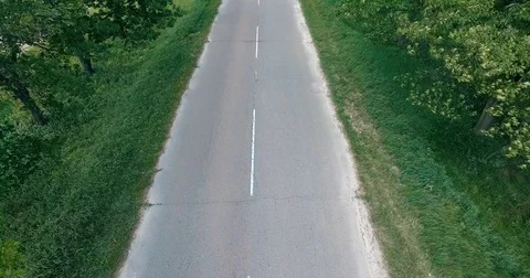 White car moving fast on two lane road in forest, above view Stock Footage 84947023