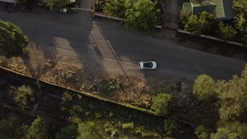 A white car is parked on the side of the road and is on its way 스톡 동영상 259791567