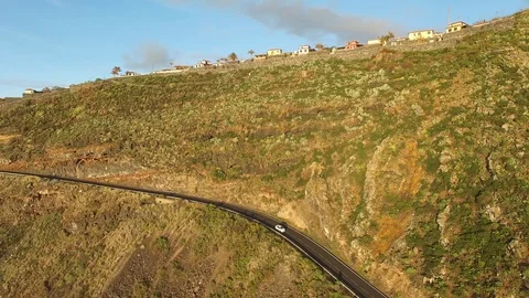 White car passing through mountains near the Ocean - Tenerife, Spain 動画素材 88287909