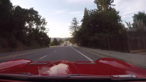 A white car pulls onto a road in front of a classic car. Vídeos de archivo 186380821