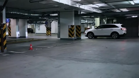 White car rides backward by underground garage Stock Footage 276370517