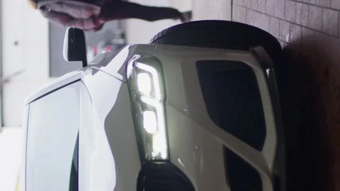 A white car slowly turns in front of the camera. The front side of the car. Video stock 233461204