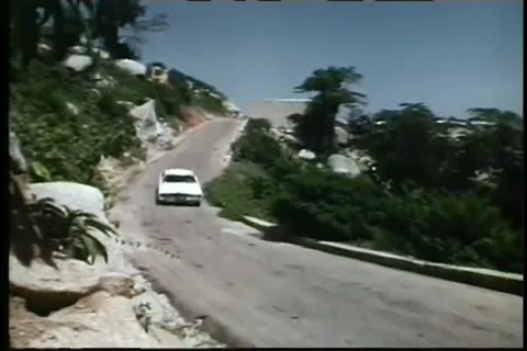 White car speeding down mountain road Vídeos de archivo 11350674