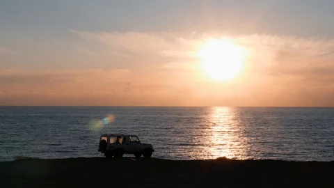 White car standing on cliff against pink sunset.  Cliff with car standing on it Stock Footage 114686008