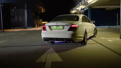 White car start enging go reverse and then drive from the back Stock Footage 88692995