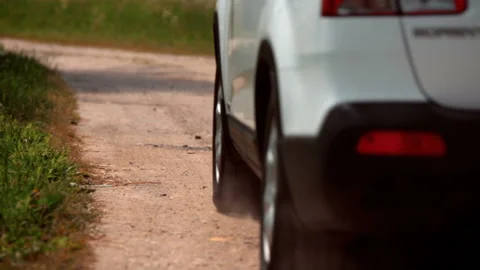 White car (SUV) rides along a ground road raising dust behind itself Stock Footage 119496591