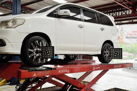 White car is undergoing wheel corner alignment maintenance Stock Photos