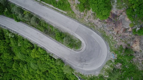 The white car is a very sharp turn on a mountain road. Aerial view. Stock-Footage 91014886