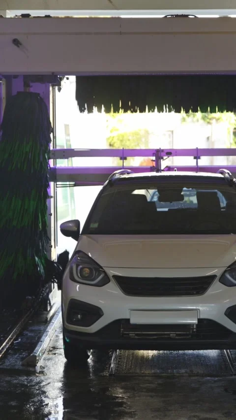 A white car without license plates in an automatic car wash Stock Footage 329547226