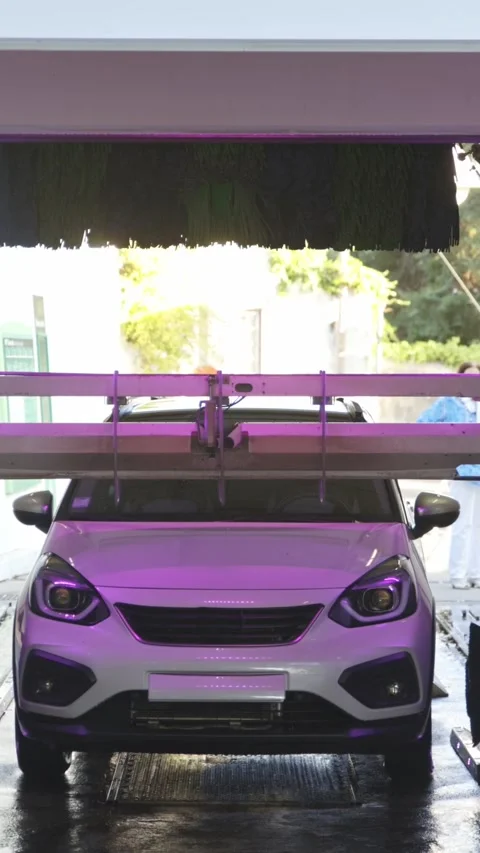 A white car without license plates in an automatic car wash - the mechanism for Stock Footage 329547264