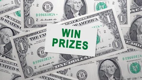 A white card with the message WIN PRIZES in green text sits atop a pile of .. Stock Photos