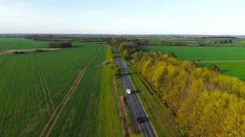 White cargo van delivering parcels along rural road between green fields and Stock Footage 334846304