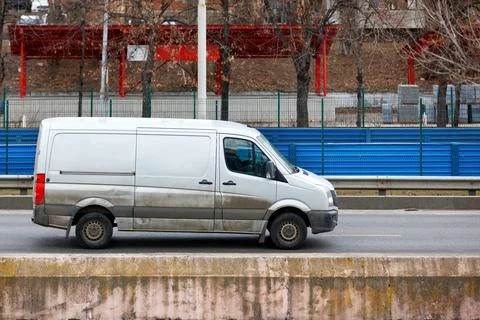 A white cargo van drives down the highway on a spring afternoon. 스톡 사진