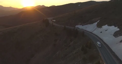 White cargo van or bus driving down the mountain road at sunset time Video stock 129225341