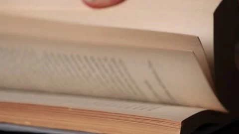 White Caucasian hand flipping through a book in slow motion Stock Footage 146948892