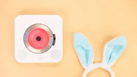 White cd player with red disc with bunny ears on yellow background. Love musi Foto stock