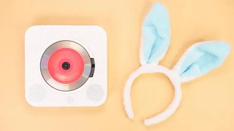 White cd player with red disc with bunny ears on yellow background. Love music Foto stock