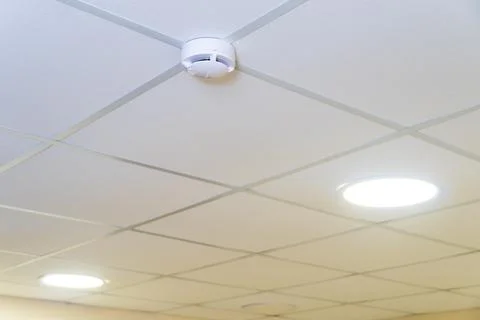 White ceiling with backlight and smoke detector in the office space. Round la Foto stock