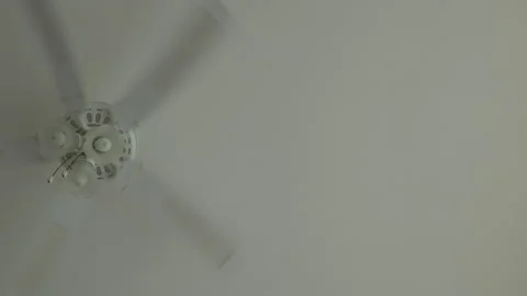 White ceiling fan spinning blades handheld static shot Stock Footage 343375514
