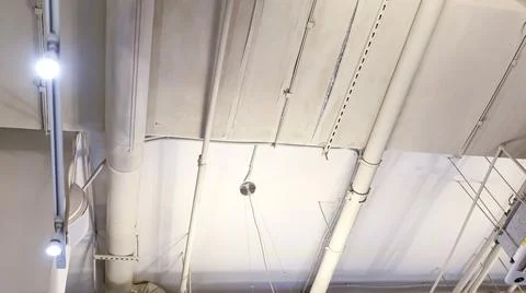 White ceiling with pipes and high-tech lamps Stock Photos