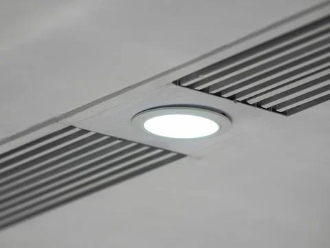 White ceiling with a poorly  mounted built-in round led light in a panel wi.. Stock Photos