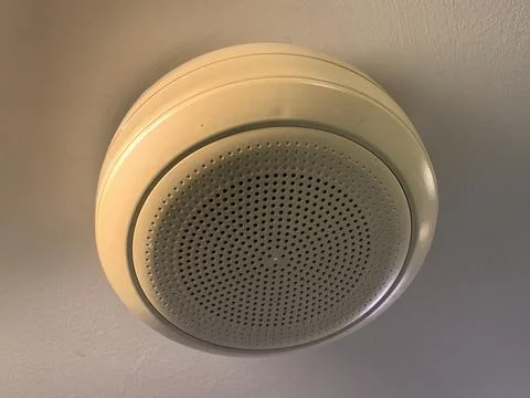 White ceiling speaker with white ceiling, commonly used to play music Stock Photos