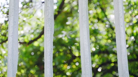 White cement fence with grid pattern in front of blurred trees and sky, concrete Stock Footage 260735814