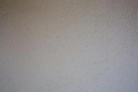 White cement wall with tiny rock on surface texture, grunge background. Stock Photos